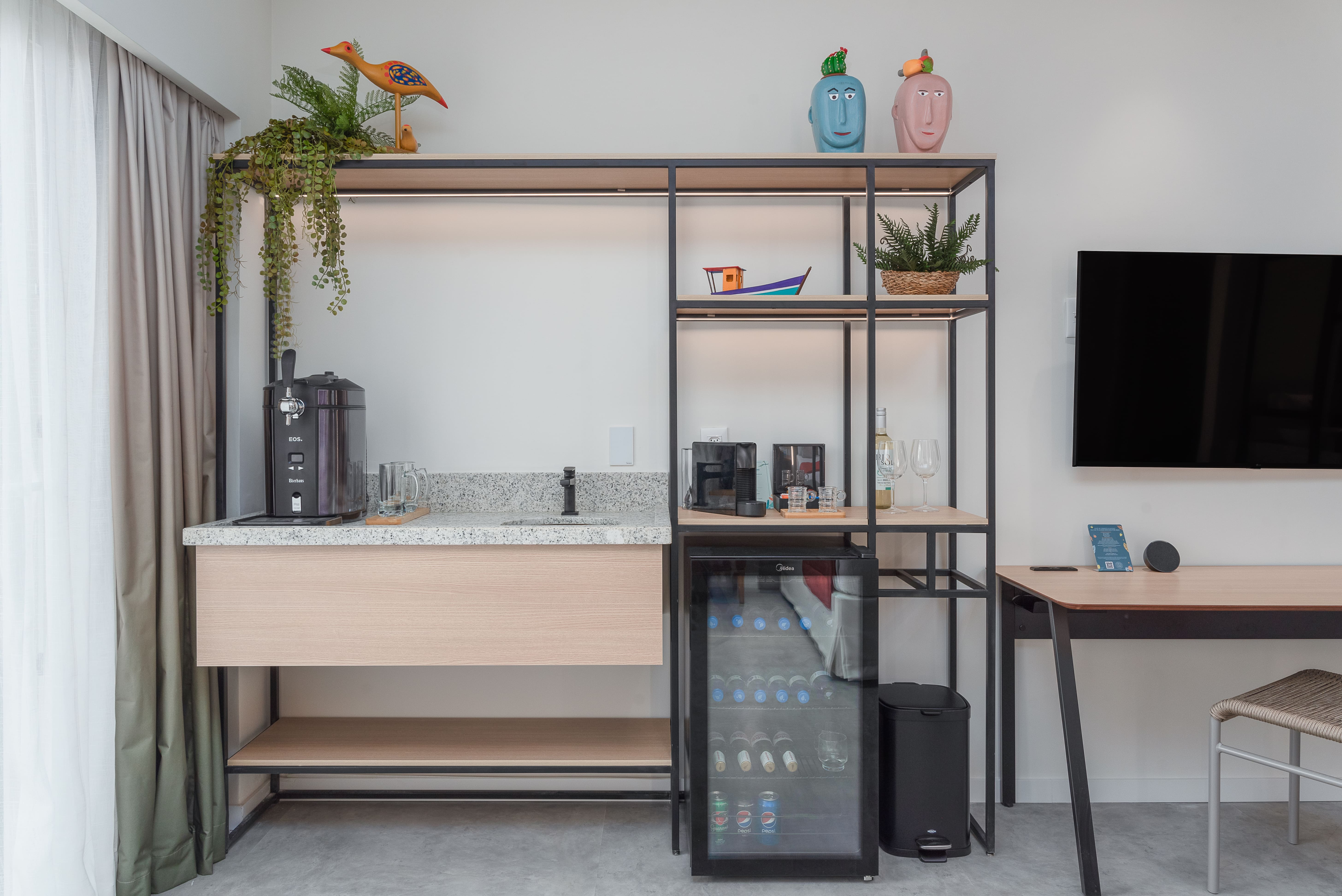 Imagem mostrando área de consumo do Garden Exclusive com chopeira, cafeteira Nespresso, frigobar, Alexa e mais.